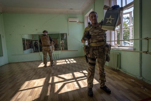 Ukraine, September 2022. A team of the Ukranian volunteer army visits the interior of the house of culture in Izyum where the Russians had installed their central command for months of occupation. After their rapid retreat, the Ukranian soldiers find numerous remains of the Russian staySoldiers from the Ukrainian volunteer army walk in front among the ruins of the city of IzyumThe Ukrainian city of Izium (Izyum) is related  with the mass burial site discovered near by. But there are people still living there. Russia heavily bombarded the town. In  September, its forces left the area leaving behind destroyed infrastructure and a population with no food and no water and under shock.
